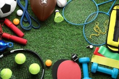 Yeşil çimlerin üzerinde farklı renkte spor aletleri var. Metin için boşluk