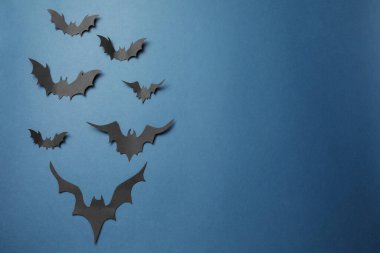 Koyu mavi arka planda bir sürü kağıt yarasa, düz yerde metin için uzanıyordu. Cadılar Bayramı