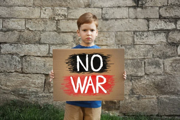 Smutny Chłopiec Trzymający Plakat Słowami War Brick Wall Outdoors — Zdjęcie stockowe