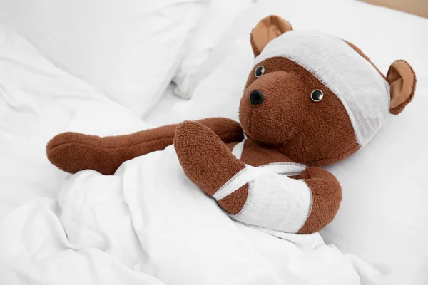 Mainan Beruang Dengan Perban Tergeletak Tempat Tidur — Stok Foto