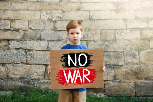 Smutny Chłopiec Trzymający Plakat Słowami War Brick Wall Outdoors — Zdjęcie stockowe