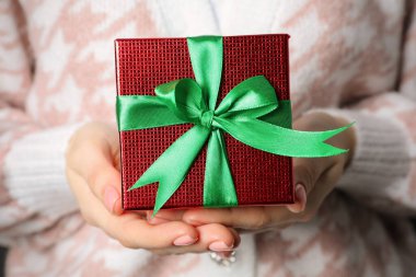 Noel hediyesi. Güzel paketlenmiş hediye kutusunu tutan kadın, yakın plan.