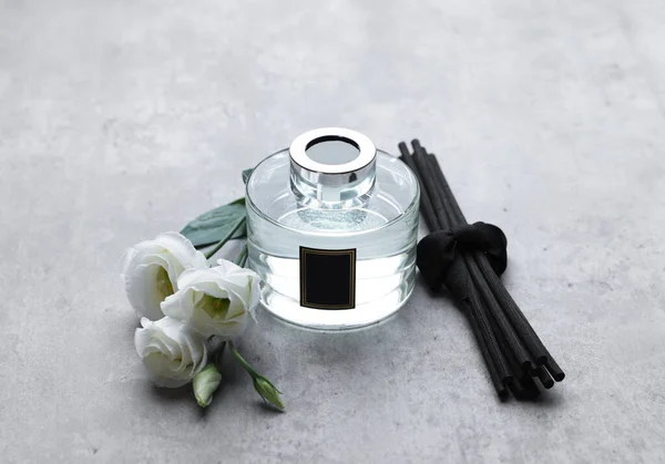 Schilfstangen Glasflasche Mit Aromatischer Flüssigkeit Und Eustoma Blüten Auf Grauem — Stockfoto