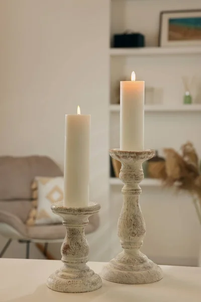部屋の白いテーブルの上に美しい木製の燭台 — ストック写真