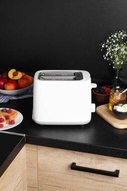 Modern tost makinesi, ekmek, taze böğürtlen ve bal mutfak tezgahında.
