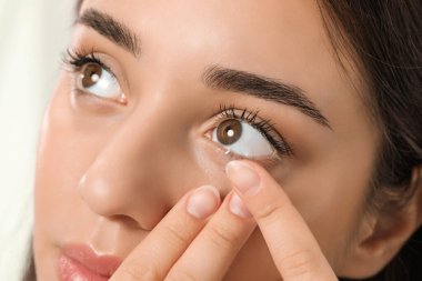 Gözüne kontak lens takan kadın, yakın çekim görüntüsü.