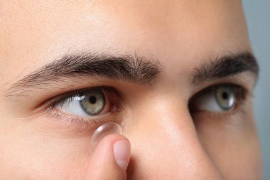 Kontak lens takan genç adamın yakın görüntüsü