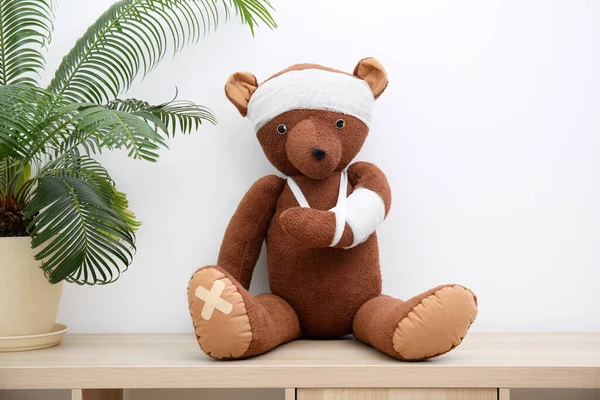 Urso Brinquedo Com Ataduras Sentado Unidade Estantes Madeira Perto Parede — Fotografia de Stock