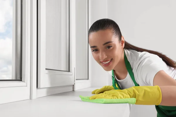 Alegre Joven Mujer Limpieza Ventana Alféizar Con Trapo Interior —  Fotos de Stock