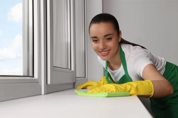 Alegre Joven Mujer Limpieza Ventana Alféizar Con Trapo Interior —  Fotos de Stock