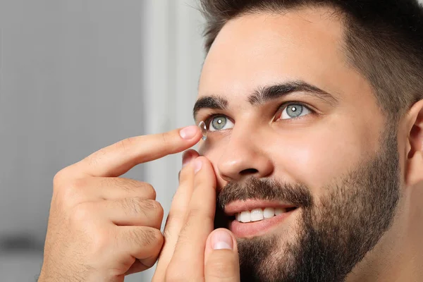 Vista Cerca Joven Que Pone Lentes Contacto Sobre Fondo Borroso — Foto de Stock