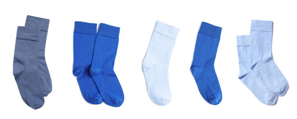 Set with pairs of different color socks on white background, top view. Banner design