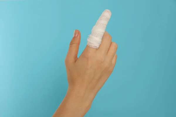 Kvinna Med Finger Insvept Medicinskt Bandage Ljusblå Bakgrund Närbild — Stockfoto