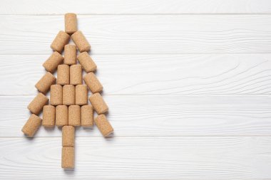Beyaz ahşap masadaki şarap mantarlarından yapılmış Noel ağacı, üst manzara. Metin için boşluk