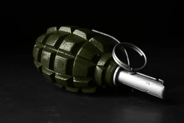 Hand grenade on black background, closeup. Explosive weapon