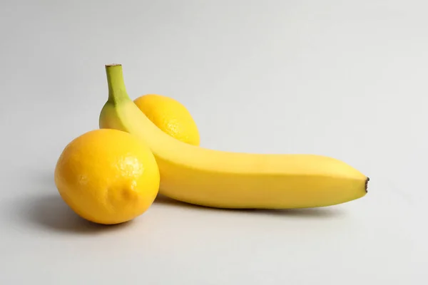 ライトグレーの背景にオスの性器を象徴するバナナとレモン ポテンシャル概念 — ストック写真