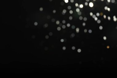 Siyah arkaplandaki neşeli ışıkların bulanık görüntüsü. Bokeh etkisi