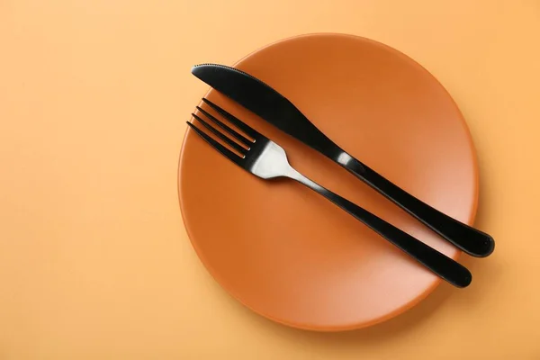 Ceramic Plate Cutlery Pale Orange Background Top View Space Text — Stock Photo, Image