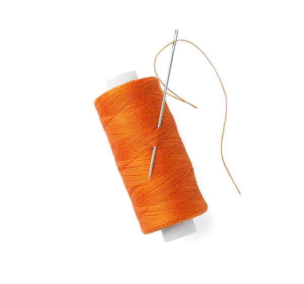 白いトップビューに隔離された針でオレンジの縫製糸のスプール — ストック写真