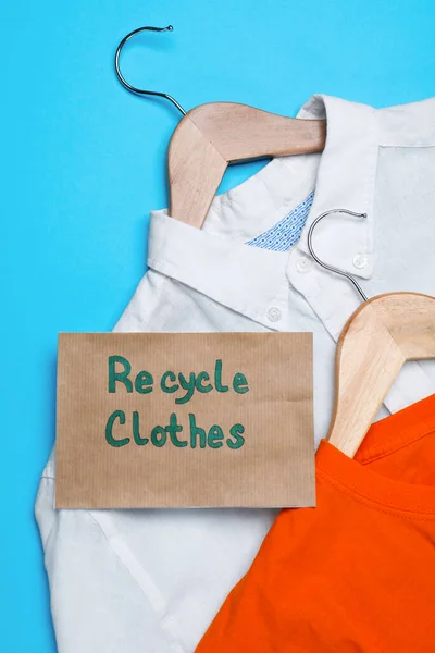 Různé Oblečení Recyklačním Štítkem Závěsy Světle Modrém Pozadí Ploché Ležely — Stock fotografie