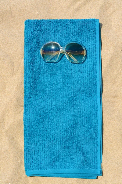 Zachte Blauwe Strandhanddoek Met Zonnebril Zand Bovenaanzicht — Stockfoto