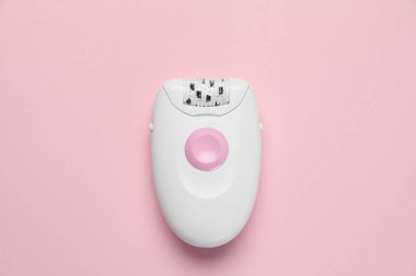 Pembe arka planda modern epilatör, üst görünüm