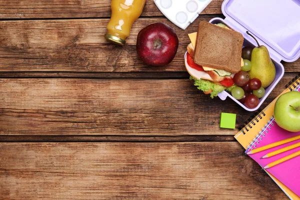 平面的作文与午餐盒 美味的健康食品和学校文具放在木制桌子上 案文的篇幅 — 图库照片
