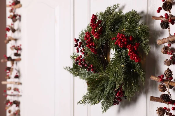 Beyaz Kapıda Kırmızı Böğürtlen Peri Işıkları Asılı Güzel Noel Çelengi — Stok fotoğraf