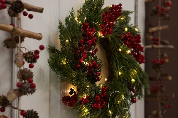 Kırmızı Böğürtlenli Güzel Noel Çelengi Beyaz Kapıya Asılı Peri Işıkları — Stok fotoğraf
