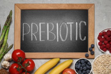 Prebiyotik ve farklı ürünler içeren karatahta gri masa, düz yatıyordu