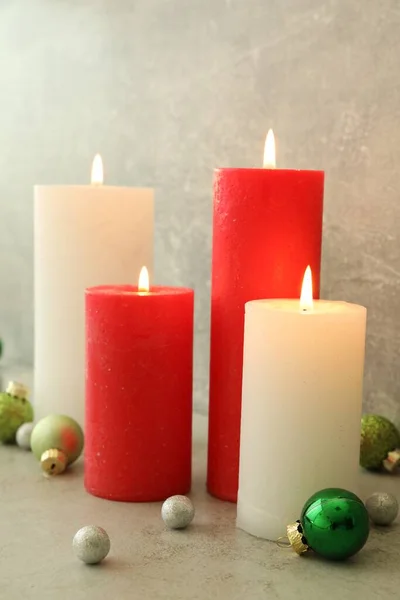 Горящие Свечи Рождественскими Безделушками Светло Сером Столе — стоковое фото