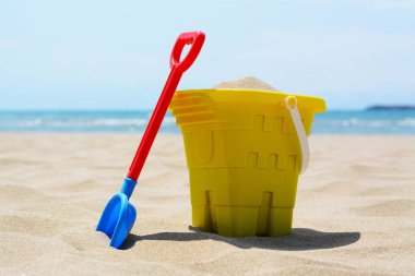 Plastik kova ve kumda kürek. Plaj oyuncakları