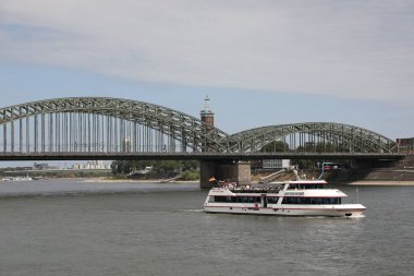 Köln, Almanya - 28 Ağustos 2022: Nehir ve feribot üzerinde modern bir köprü manzarası