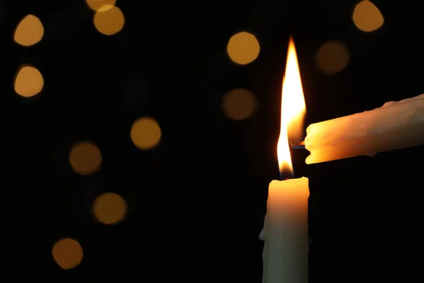 在黑暗中 在朦胧的灯光下点燃另一个人的蜡烛 案文的篇幅 — 图库照片