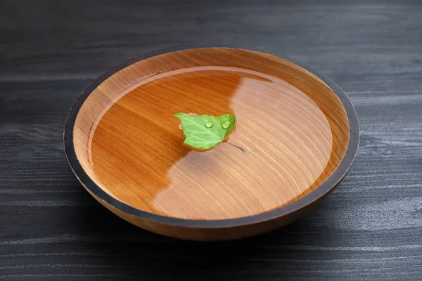 Bowl Water Green Leaf Dark Wooden Table Closeup — Stok fotoğraf