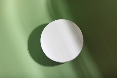Soluk yeşil arka planda ürün sunumu için yuvarlak podyum, üst görünüm