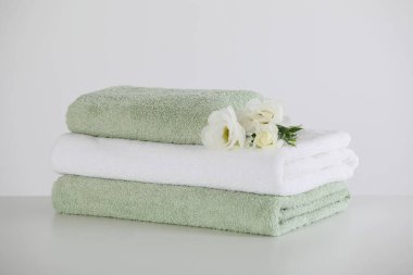 Beyaz masa üzerinde östoma çiçekleri olan yumuşak katlanmış havlular.