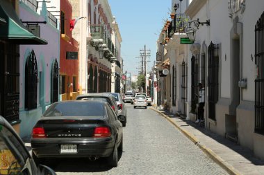 MONTERREY (NUEVO LEON), MEXICO - 29 Eylül 2022: Güneşli bir günde park halindeki arabalarla şehir caddesinin güzel manzarası