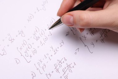Kağıt üzerine farklı matematiksel formüller yazan öğrenci, yakın plan