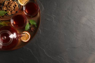 Geleneksel Türk çayı, ceviz, kurutulmuş portakal ve siyah masada anason içeren tepsi, üst manzara. Metin için boşluk