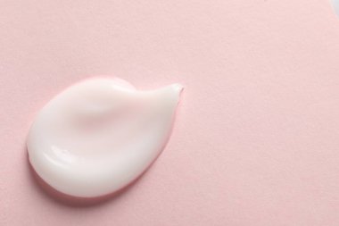 Pembe arka planda yüz kremi örneği, üst manzara. Metin için boşluk