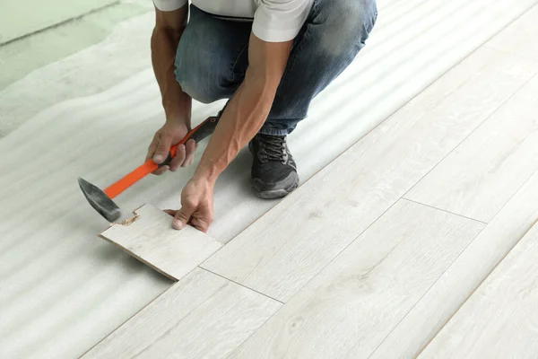 Man Using Hammer Installation New Laminate Flooring Close Seup — стоковое фото