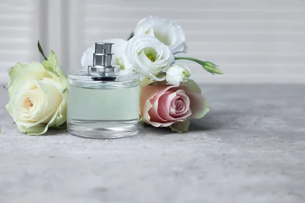 Bottle Perfume Flowers Grey Table Indoors — Zdjęcie stockowe