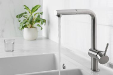 Stream of water flowing from tap in kitchen