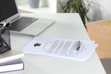 Üniversitelerden ve laptoptan kabul mektupları beyaz masa içinde.