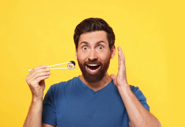 Homme Émotionnel Tenant Rouleau Sushi Avec Baguettes Sur Fond Orange — Photo