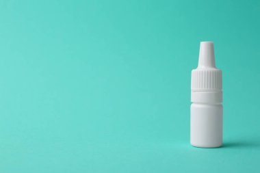 Turkuaz arka planda bir şişe tıbbi damla. Metin için boşluk