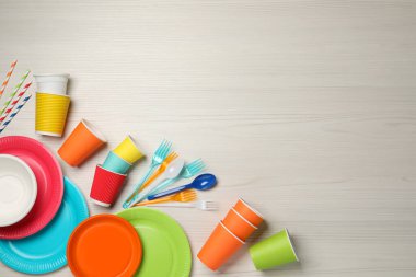 Beyaz ahşap arkaplan üzerinde farklı tek kullanımlık tablo eşyasına sahip düz konum, metin için boşluk