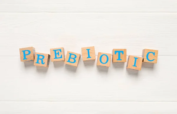 单词Prebiotic由立方体制成 上面有白色木制桌子上的字母 顶视图 — 图库照片