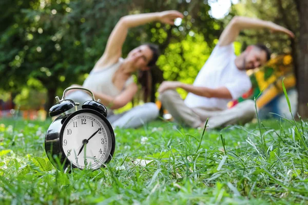 公園で朝の運動をする男と女目覚まし時計に焦点を当て — ストック写真